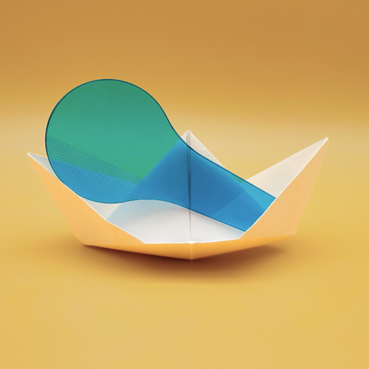 A translucent folding origami boat made of white paper, with a green and blue translucent panel inserted inside, set against a warm yellow gradient background.